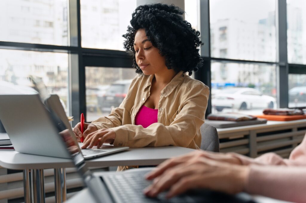 Imagem de uma mulher digitando no computador para ilustrar artigo sobre agência de redator. Foto: Freepik.