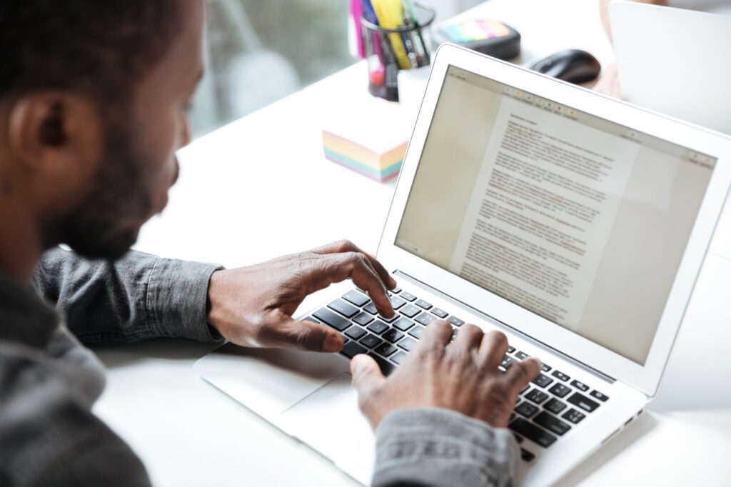 Imagem de um homem digitando no computador para ilustrar artigo sobre agência de redator. Foto: Freepik.