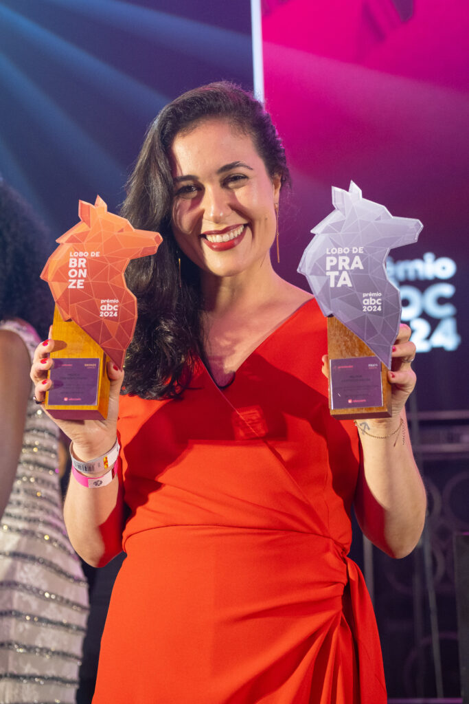 Foto de Flávia Miranda sendo premiada com o troféu do Prêmio ABC,